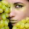 Young beautiful woman holding green grapes closeup