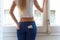 Young beautiful woman at home with mobile phone in back pocket.