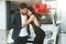 Young beautiful woman looks grateful receiving brand new car for present from her boyfriend hugging him in dealership