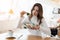 Young beautiful woman looks unsatisfied with quality of salad holding piece of green leaf, looking unhappy during lunch time at