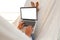 Young beautiful woman lying in a hammock with a laptop at the resort. Mock up, blank white screen