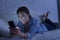 Young beautiful woman lying on home couch using mobile phone internet addiction concept