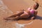 Young beautiful woman in pink bikini laying