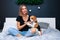 Young beautiful woman playing with dog sitting on bed in a stylish bedroom