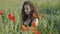 Young beautiful woman plucking red flower and putting it in hair. Portrait of relaxed charming Caucasian lady enjoying