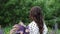 Young beautiful woman posing in a field with a bouquet of lilac flowers. happy brunette in a field of lupins