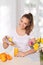 Young beautiful woman pouring orange juice into the glass