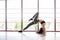 Young beautiful woman practicing yoga in fitness gym or yoga studio. Wellness concept. Calmness and relax, woman happiness.