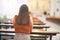 Young beautiful woman praying on her knees in a bench backwards at church