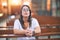 Young beautiful woman praying on her knees in a bench at church