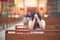 Young beautiful woman praying on her knees in a bench at church