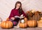 Young beautiful woman with pumpkins. Beautiful girl with glasses reads a book. Young pretty woman reading a book.