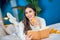 Young beautiful woman reading a book and eating mandarin