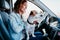 young beautiful woman reading a map in a car. travel concept. cute jack Russel dog besides