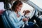 young beautiful woman reading a map in a car. travel concept. cute jack Russel dog besides