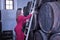 Young beautiful woman in a red dress climbing a ladder to check the wine barrels in her cellar. Concept businesswoman,