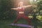 Young beautiful woman in red leggings and a top practicing yoga in a city park