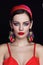 Young beautiful woman with red lips and fancy massive earrings