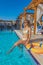 Young beautiful woman is relaxing and swimming in the blue swimming-pool closeup with orange lifesaver.