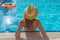 Young beautiful woman is relaxing and swimming in the blue swimming-pool closeup with orange lifesaver.