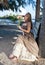 young beautiful woman in a romantic dress on a bench on a beach, tropics