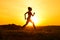 Young Beautiful Woman Running on the Mountain Trail at Hot Summer Sunset. Sport and Active Lifestyle