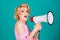 Young beautiful woman screaming in megaphone, isolated on background studio portrait. Shout girl speaks in a loudspeaker