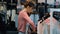 Young beautiful woman seller in a denim store hangs clothes on hangers