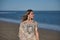 Young and beautiful woman with sequined shirt and bangs, walking on the beach, calm and relaxed, in solitude. Concept beauty,