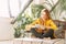 A young beautiful woman sits on the Internet in her home garden on a tablet. The girl searches the Internet for information about