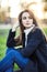 Young beautiful woman sitting on a grass in sun light on sunset