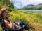 A young beautiful woman sitting in her camping chair at a beautiful campsite along the bow river.