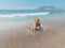 Young beautiful woman is sitting on the sea cost and enjoying waves landscape. Alanya, Turkey