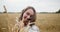 Young beautiful woman smiling and having fun in a summer wheat field close-up