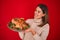 Young beautiful woman smiling proud holding thanksgiving turkey chicken on a tray over red background