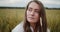 Young beautiful woman smiling in a summer wheat field close-up