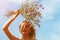 Young beautiful woman smiling to the sun holding a bouquet of wildflowers above her head