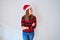 Young beautiful woman smilling happy wearing striped sweater and a santa claus hat at christmas