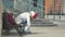 Young beautiful woman in sporty warm clothes and rollers, sitting on a wooden bench and dresses roller skates getting