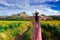 Young beautiful woman stands with her back turned on a blurred background with a field of sunflowers at Lopburi,Thailand