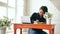 Young beautiful woman student sitting with laptop and writing book at cafe indoors