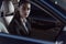 Young beautiful woman in suit sitting in a drivers seat of