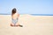 Young beautiful woman sunbathing sitting on the sand wearing summer swinsuit at maspalomas dunes bech