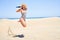 Young beautiful woman sunbathing wearing summer swinsuit jumping crazy at maspalomas dunes bech