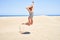 Young beautiful woman sunbathing wearing summer swinsuit jumping crazy at maspalomas dunes bech