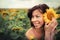 Young beautiful woman in a sunflower field. Summer picnic