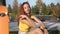 Young beautiful woman teenager in the park listens to music using wireless headphones. Attractive redhead woman outdoors
