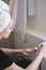 Young beautiful woman with towel on her head after shower in bathroom applies nail polish. The concept of female morning