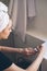 Young beautiful woman with towel on her head after shower in bathroom applies nail polish. The concept of female morning