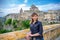 Young beautiful woman traveler with black jacket looking at camera, smile, posing and keep spikelet in Sassi di Matera